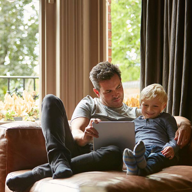 man and kid sitting on couch