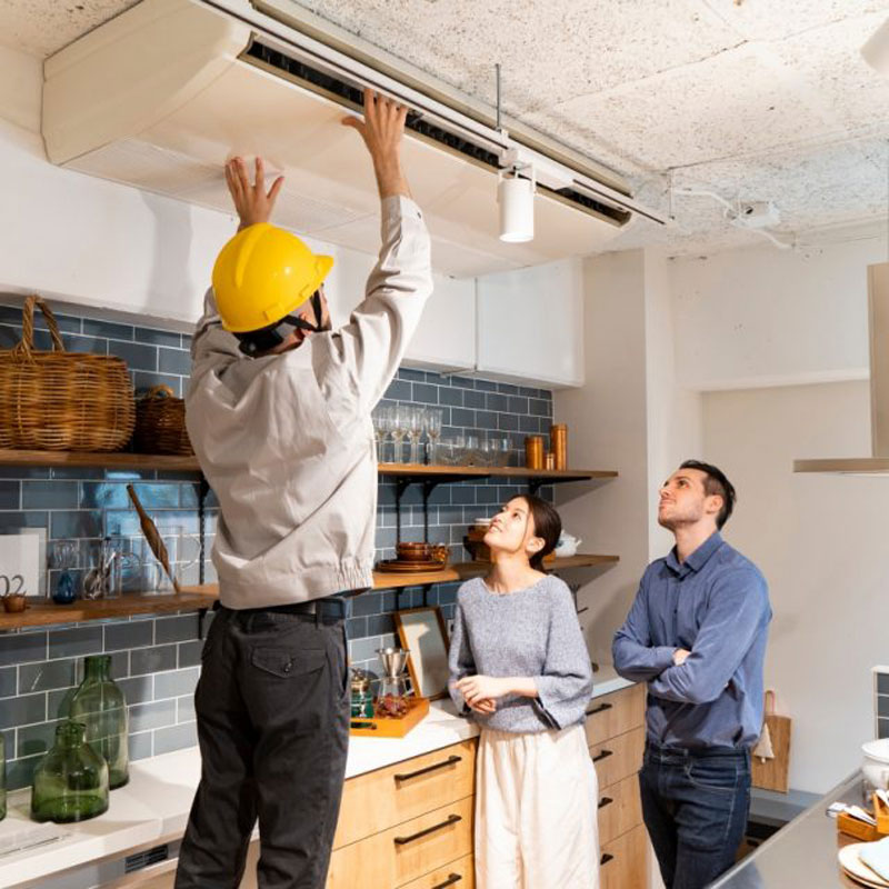 people in kitchen repairing hood